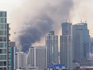 Black smoke caused by a fire in a downtown Bangkok building, Danger from using electricity or broken electrical wires, Selective focus.