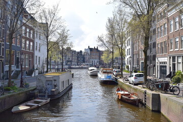 Beautiful view from the bridge over the canal with boats and curved houses in Amsterdam, Netherlands