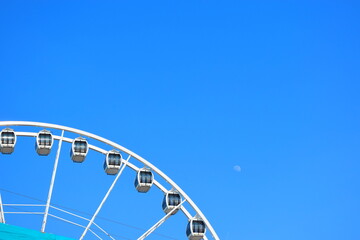 The Ferris wheel against a blue sky and moon at the resort of Scheveningen (The Hague) in the Netherlands. Europe's first Ferris Wheel over the Sea