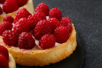 Fruit raspberry tart cakes on a black tabe. mini tart pie with berries