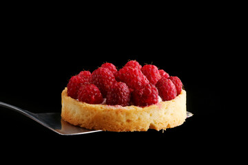 raspberry tart close up isolated on black. mini tart pie