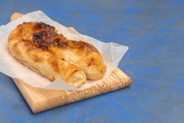 Traditional Bulgarian cheese pastry Banitsa on wooden board