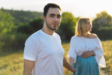 Happy and young pregnant couple in outdoors