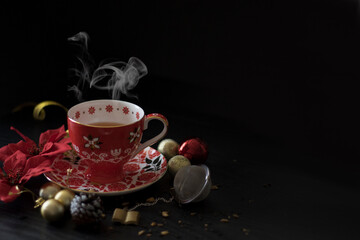 Obraz na płótnie Canvas Side View of Christmas Tea Cup with Steam, shot against dark background. Chinese Tea for Christmas. Dark Food Photography for Christmas. 