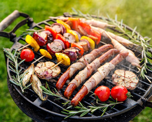 Grilled various food, sausages and vegetable and meat skewers with herbs on a cast iron grill
 close up view