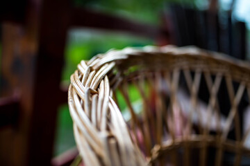 Fototapeta na wymiar Rattan chair arm in focus on the patio, shallow depth of field with copy space.