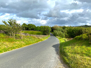 Fototapeta na wymiar Country road, with trees, grass, and cloudy weather near, Bradford, Yorkshire, UK