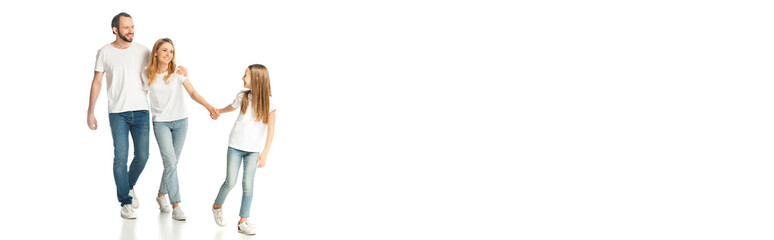 happy casual family holding hands while walking isolated on white, panoramic shot