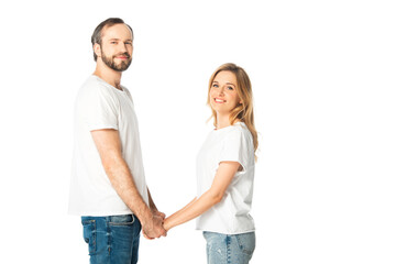 side view of adult couple in white t-shirts holding hands isolated on white