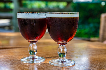 Glasses with cold dark strong Belgian beer served outdoor