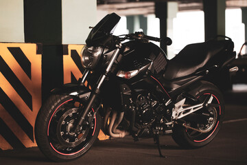 Fototapeta na wymiar Black motorcycle on the background of underground parking.
