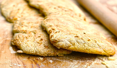 two ciabatta bread loaf fresh bake close up photo on kitchen board with flour knife and roller