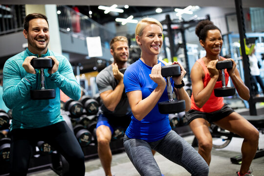 Attractive sports people friends are working out in gym