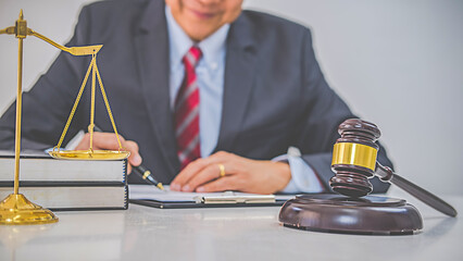 Judge gavel with Justice lawyers having team meeting at law firm background. Concepts of Law and Legal services.