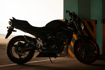 Black motorcycle on the background of underground parking.