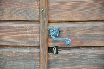 A handle on a wooden door. Deatil on old wooden brown door