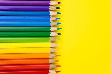 Colored pencils, made up of the colors of the rainbow on yellow background. Back to the school....