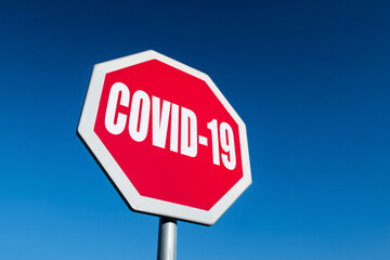 A stop traffic sign to block spreading COVID-19 disease with blue sky