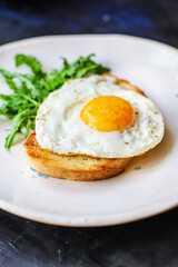 Fototapeta premium Sałatka z jajkiem sadzonym i tostem, chlebem, pysznym śniadaniem, przekąską, żółtkiem i białkiem, tło żywności, widok z góry, przestrzeń do kopiowania, zdrowe odżywianie, surowe, na wynos