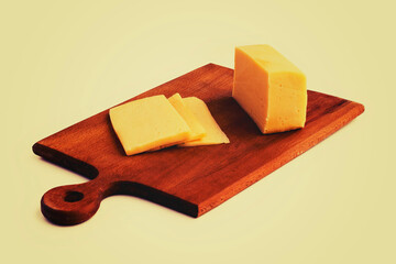 on a white background. No isolation. A small piece of cheese is cut into wedges. And a kitchen knife Close-up.