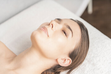 エステサロンで横になる若い女性のリラックスした顔