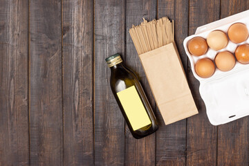 Cooking. Eggs, pasta and olive oil on a wooden table.