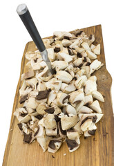 chopped champignons and knife on a wooden board