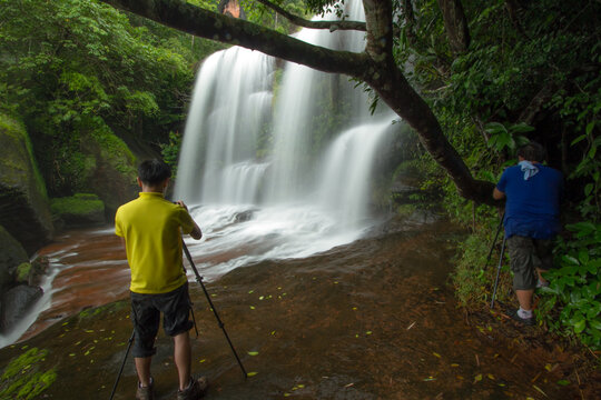 photographer taking photo waterfall in the forest 