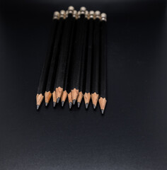 Closeup of group black wooden pencil on black background