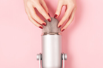 Woman hand with perfect manicure gently touching the microphone. She is about to do nail tapping....