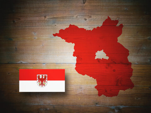 Map and flag of Brandenburg, German federal state, on wooden background, 3D illustration.