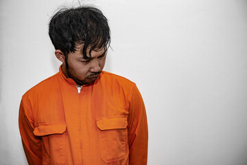 Prisoner in orange robe concept,Portrait of asian handsome man in Prison uniforms,Bandit has a lot of muscle,