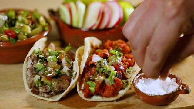 Man putting salt and lemon on his delicious tacos