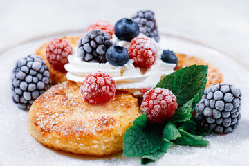 a plate with cheese cakes and berries,cheese pancake