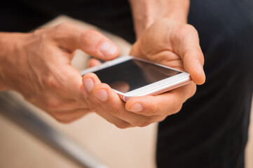 Close up, macro. Male palms are holding a smartphone.