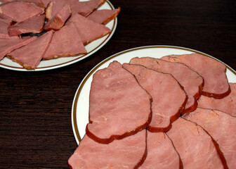 Smoked horse and beef meat slices on white plates on dark wooden background. Mixing meat delicacy, sirloin. Top view 