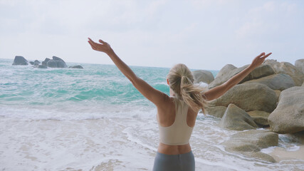 Fototapeta na wymiar Woman on the Beach with Raised Hands