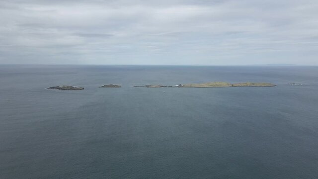 Line Of Volcanic Rocky Island's Surrounded By The Calm Water Of The Irish Sea Coast In Ireland. - aerial drone