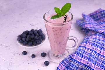 
Organic blueberry smoothie in a tall glass and fresh blueberries.Copy space.
