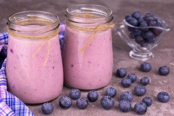 Blueberry and banana smoothie in small jars.
Organic drink.