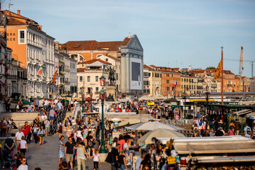 Tourist's crowd the docks of Venice Italy along the Grand Canal on a Summer evening 01