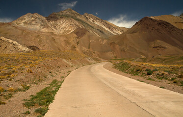 Travel. Empty desert road. Asphalt path across the arid valley and mountains. 