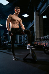 Fototapeta na wymiar Shirtless sportsman posing in gym.