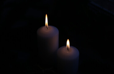 Fototapeta na wymiar white candles in the darkness with fire