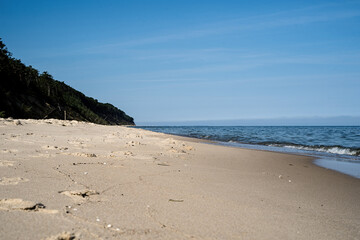Sandy beach on the Baltic Sea, view of the sea, sandy beach and dunes covered with natural forest