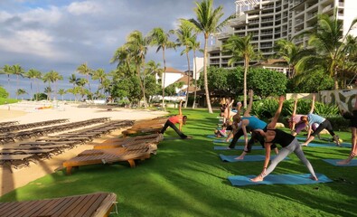 Group of people doing yoga outside at the beach © Brooke