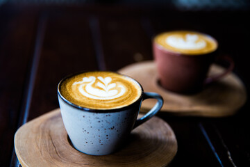 Two Cups of hot cappuccino on wooden desk background.