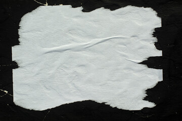 Naklejka premium White crumpled paper pasted on a black wall.