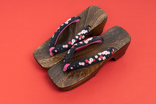 Japanese traditional geta sandal on red background. Traditional Japanese asian wood footwear called Geta