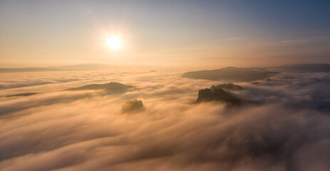 Fototapeta na wymiar Sonnenaufgang über den Wolken an den Schrammsteinen in der Sächsischen Schweiz / Sunrise above the clouds at Schrammsteine in Saxonian Switzerland